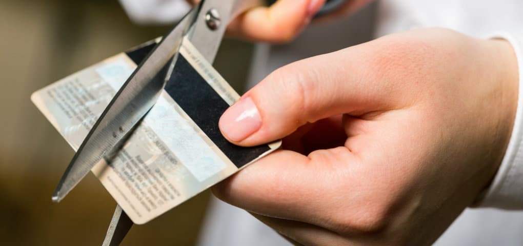 Person Cutting Credit Card with Scissors