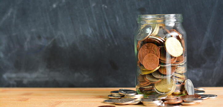 Money or coins in a full jar suggesting home savings