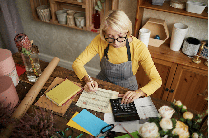 Calculating Your Business Marketing Budget: Woman with Glasses Using Calculator