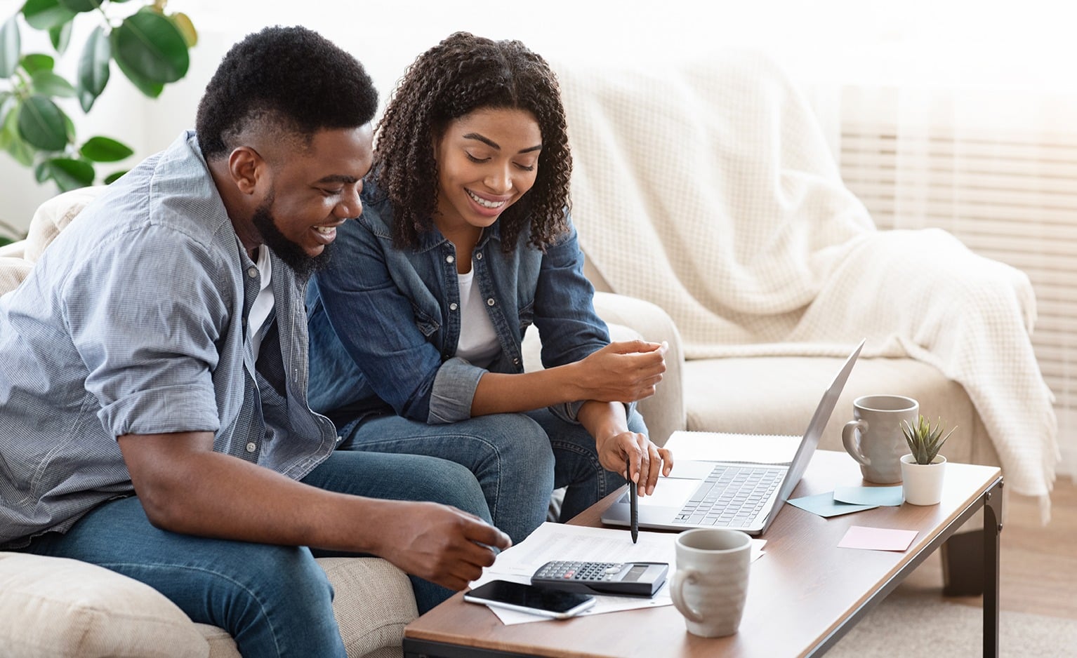 Two People Sitting on Sofa, Using a Computer