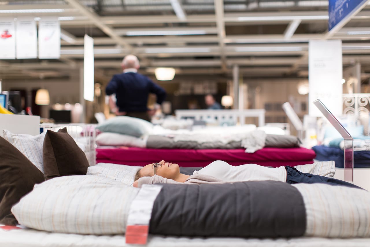 A woman lying down on a bed, relaxing while making wise purchasing decisions