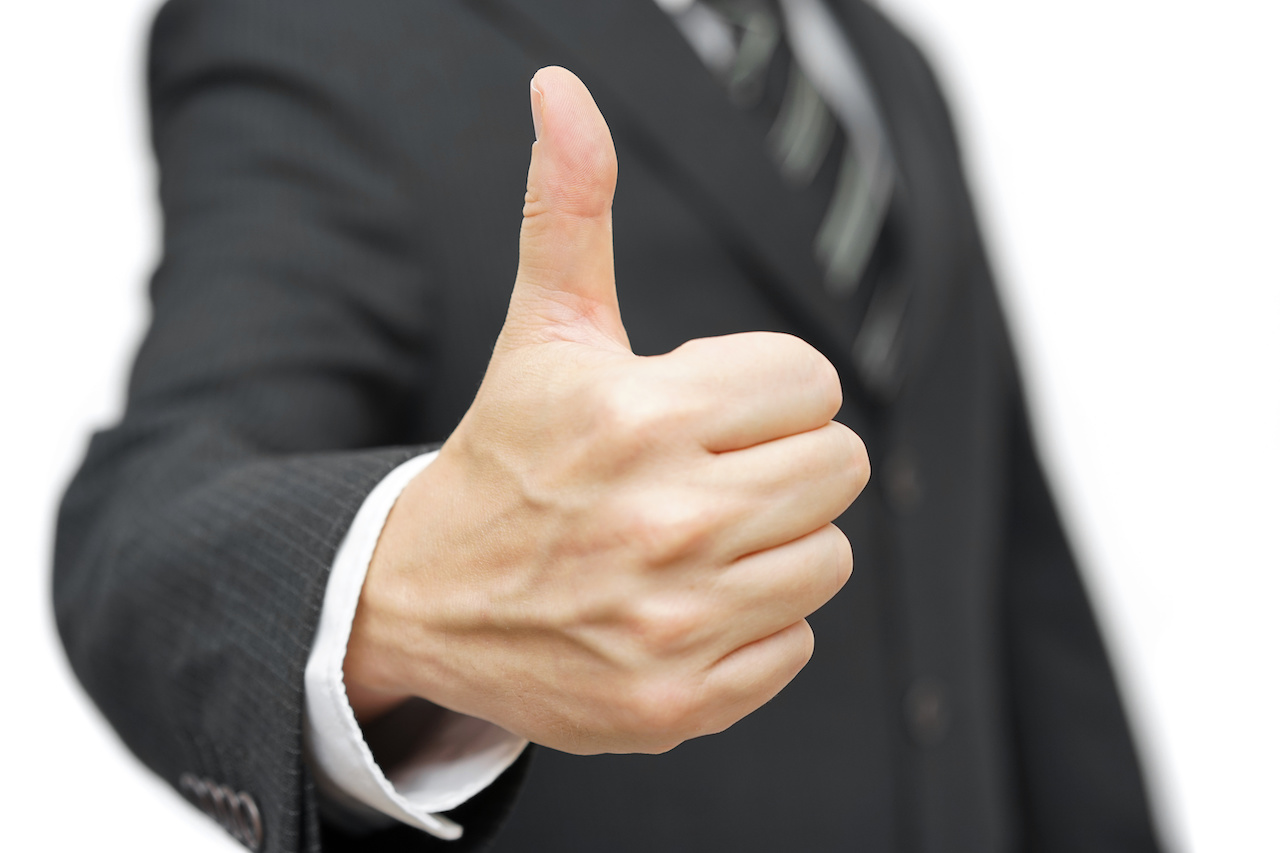 Positive Gesture: A Professional Man in a Suit Giving a Thumbs-Up Sign
