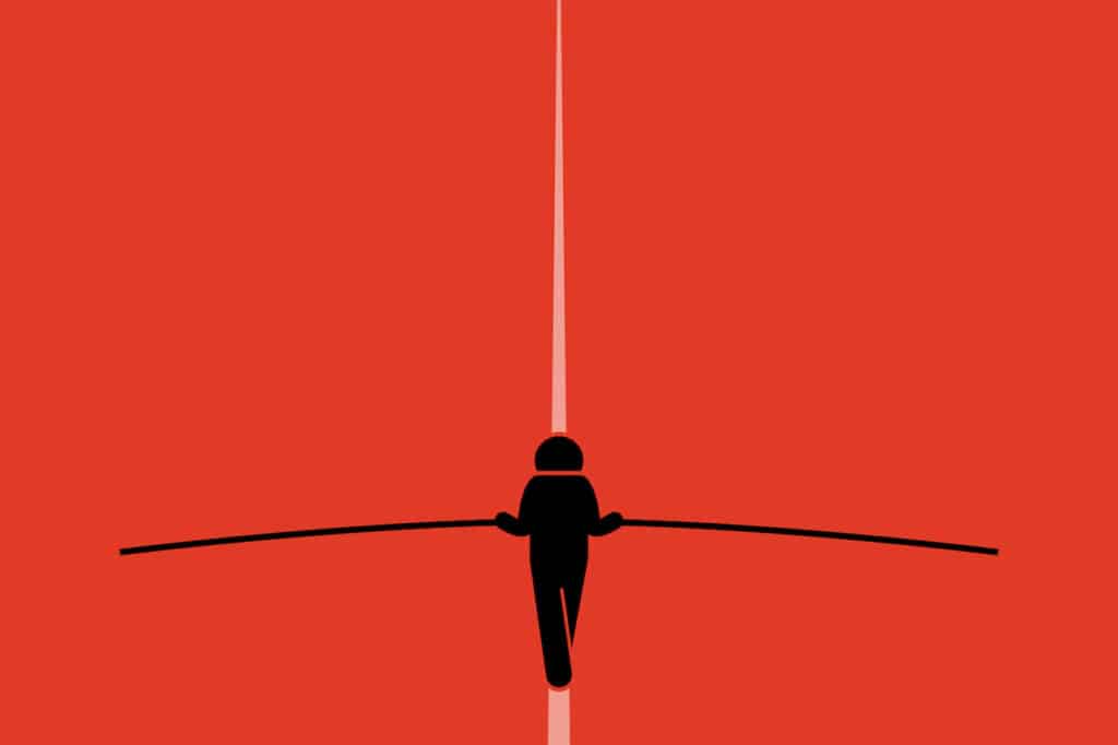 Daring Balancing Act: Man on Tightrope Against Vibrant Red Backdrop