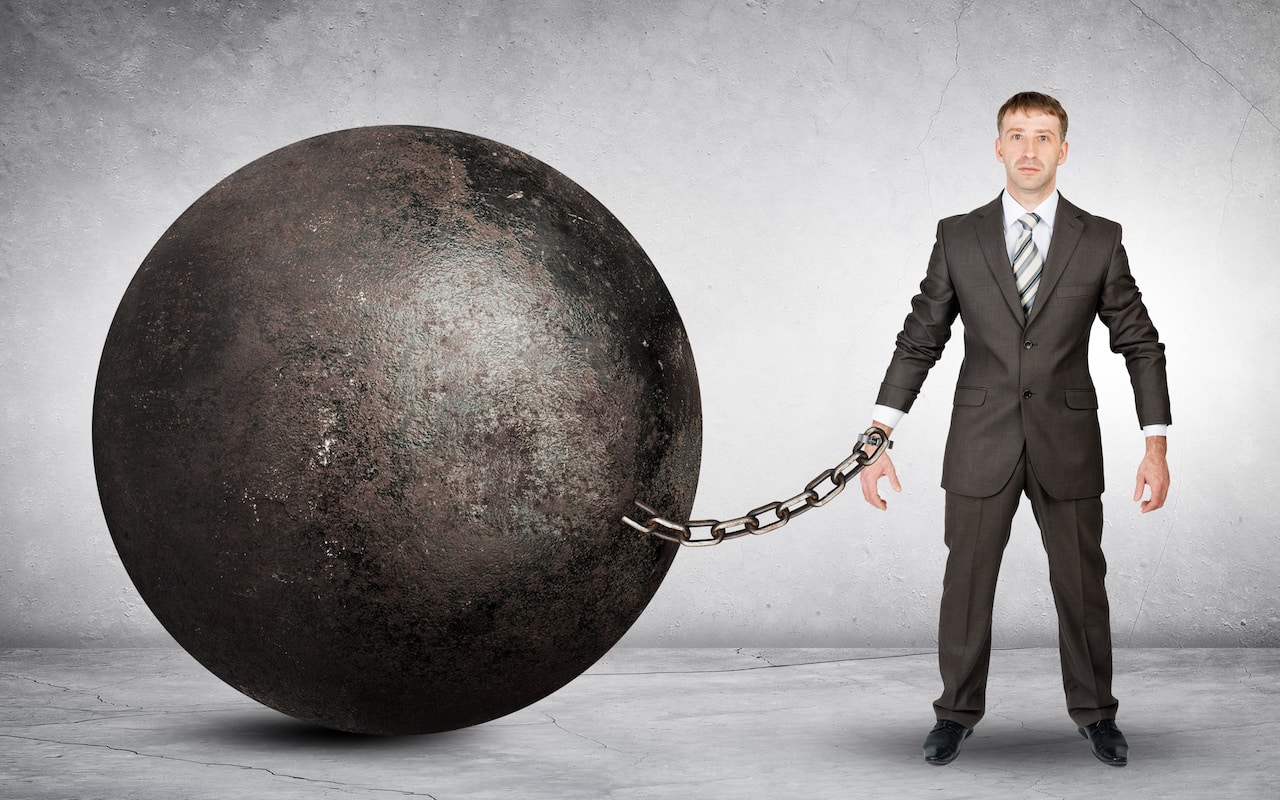 Businessman Chained to Large Ball - Symbolizing the History of Personal Loans