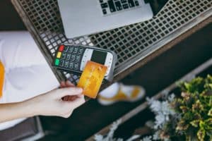 Woman Holding Credit Card at Table