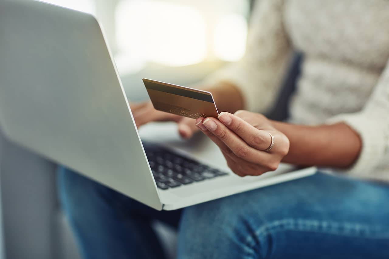 Online Shopping: Woman on Home Living Room Sofa with Laptop and Credit Card