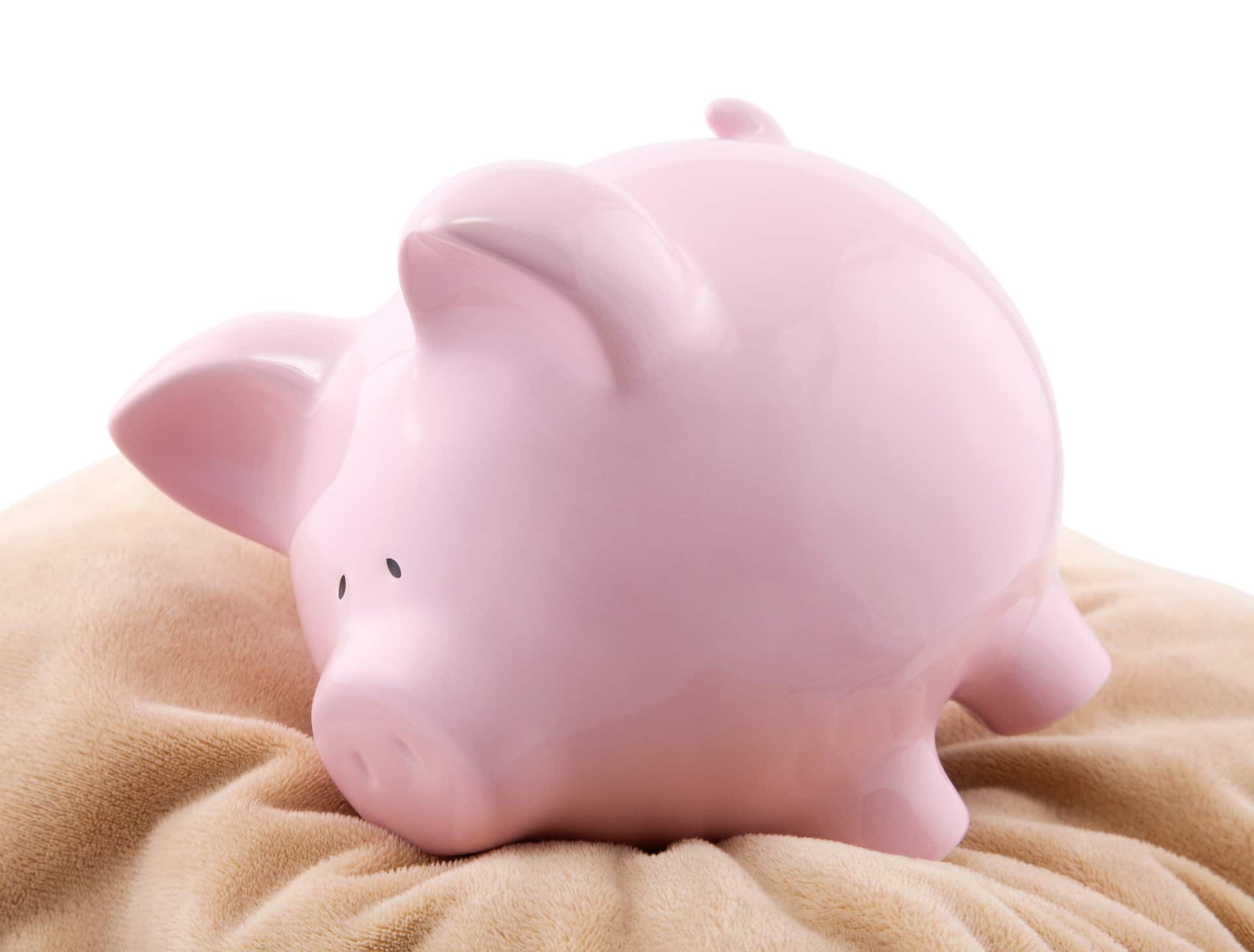 Cute Pink Piggy Bank on Soft Pillow - Symbol of Financial Security and Savings