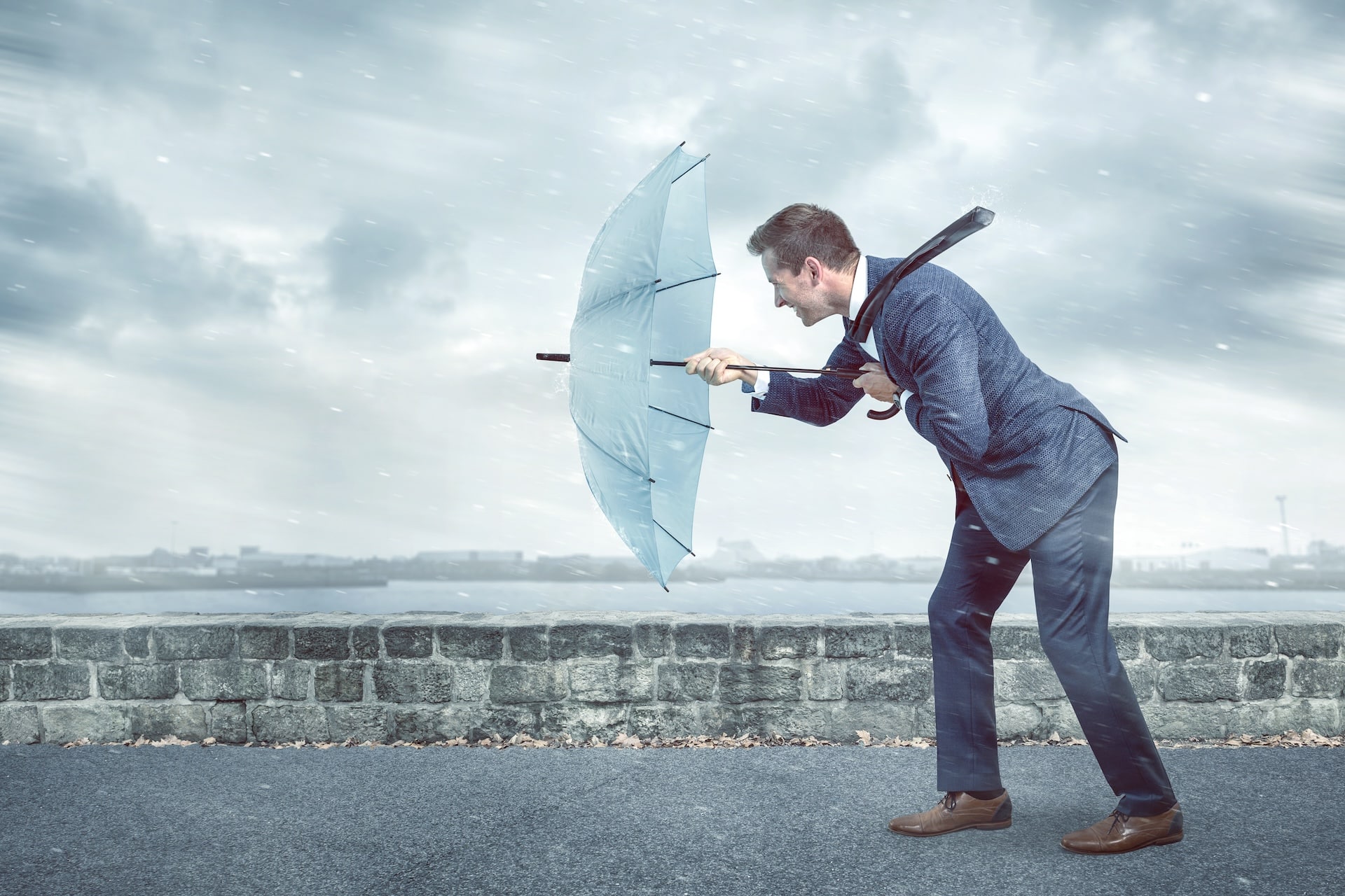 Businessman with Umbrella in Storm - Resilience in Economic Challenges